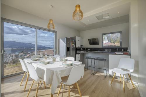 une salle à manger avec une table blanche et des chaises blanches dans l'établissement Wooden Villa 4, à Veyrier-du-Lac