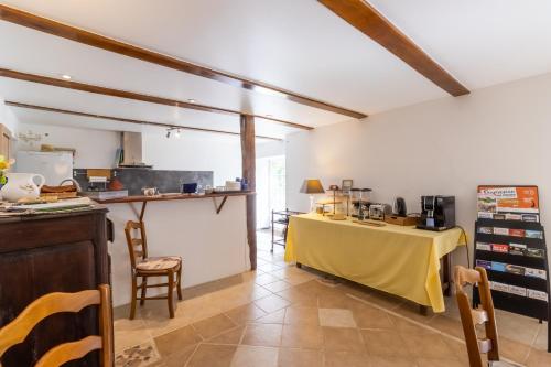 une cuisine avec une table jaune dans une pièce dans l'établissement Chambre Coquelicot, à Auriac-du-Périgord