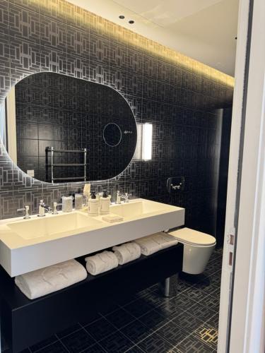 a bathroom with a sink and a mirror and a toilet at Château Rose Golfe de Saint Tropez-Grimaud in Grimaud