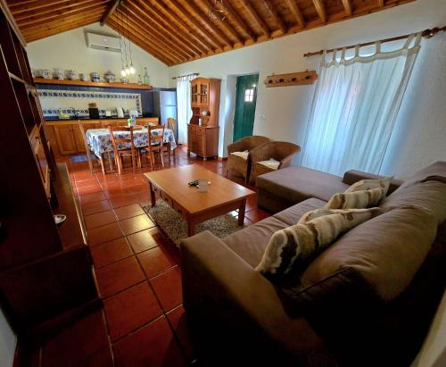 a living room with a couch and a table at Mosteiros Sea House in Mosteiros