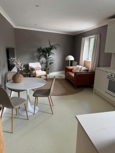 a living room with a table and chairs and a couch at Aaron Glen Guest Apartments in Loanhead