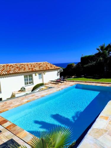 une grande piscine bleue à côté d'une maison dans l'établissement Appartement 2slaapkamers, panoramisch zeezicht, à Saint-Raphaël