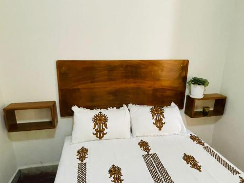 a bedroom with a bed with a wooden headboard and pillows at Bete Selam in Bahir Dar