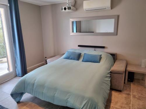 une chambre avec un lit avec deux oreillers bleus dans l'établissement Saint-Jeannet Studio apartment near Nice, à Saint-Jeannet