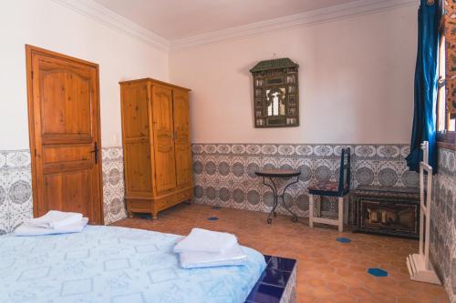 a bedroom with a bed and a clock on the wall at Roudania Tamraght Ocean View - Private Rooms And Hostel Vibes in Tamraght Ouzdar