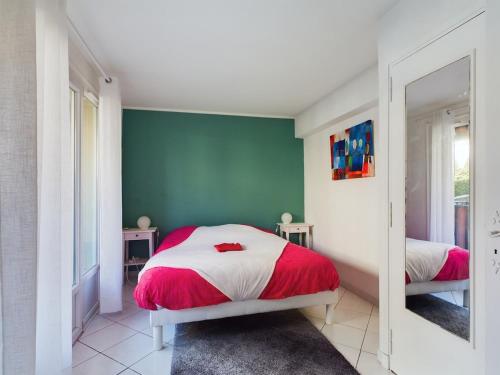 a bedroom with a red and white bed and a mirror at Charming 2-room appt, 2 steps from sea and shops in Théoule-sur-Mer