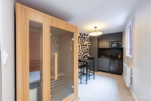 Cette chambre dispose d'une porte menant à une cuisine avec une table. dans l'établissement Le Dalmatie - Sauna - Jacuzzi - Clim - Gare SNCF, à Toulouse