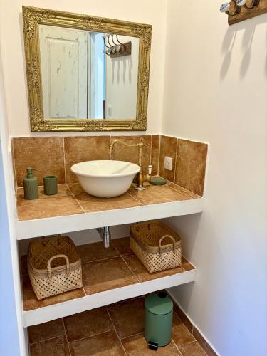une salle de bain avec un lavabo et un miroir dans l'établissement Tradition Corse et Modernité Bergerie Anto'Micheli, à Granace