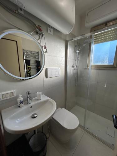 Un baño con lavabo, inodoro y espejo. en Casa Alba in Silvi Marina, en Silvi Marina