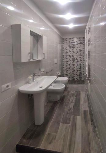 a white bathroom with a sink and a toilet at Giuius home Apartment in Camposano