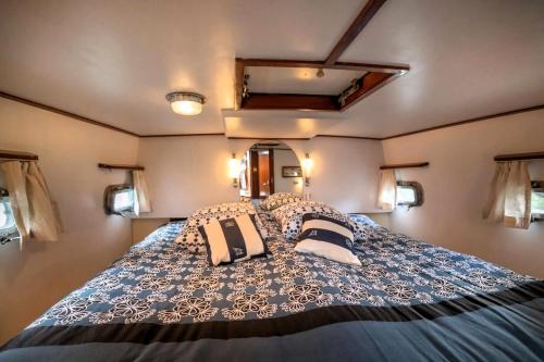 une chambre avec un grand lit avec des oreillers dessus dans l'établissement SEALOV Hébergements insolites- linge, ménage et vélos inclus, à Eaucourt-sur-Somme