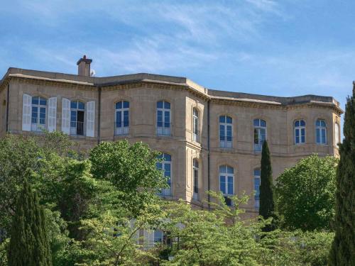 a large brick building with trees in front of it at Auberge de Jeunesse HI Marseille Bois-Luzy in Marseille