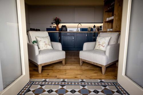 a living room with two chairs and a kitchen at Cliff View Apartment in Doolin