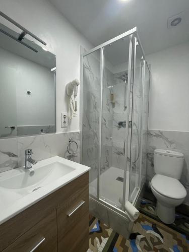 a bathroom with a shower and a toilet and a sink at Hostal Balmes Centro in Barcelona