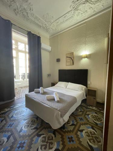 a bedroom with a bed with two towels on it at Hostal Balmes Centro in Barcelona