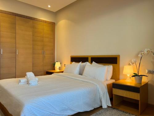 a bedroom with a large white bed with two night stands at Évasion de Rêve Luxe, Mer et Calme à la Plage des Nations, Rabat in Oulad Akkou