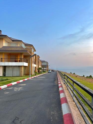 an empty road next to a building with the ocean at Évasion de Rêve Luxe, Mer et Calme à la Plage des Nations, Rabat in Oulad Akkou