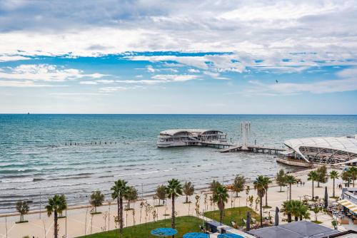 ドゥラスにあるAria Seaside Tranquility Apartmentsのヤシの木と桟橋のあるビーチの景色