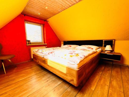 una camera con un letto con pareti rosse e gialle di Sonnenblume - Sonne 2 rechts a Zingst