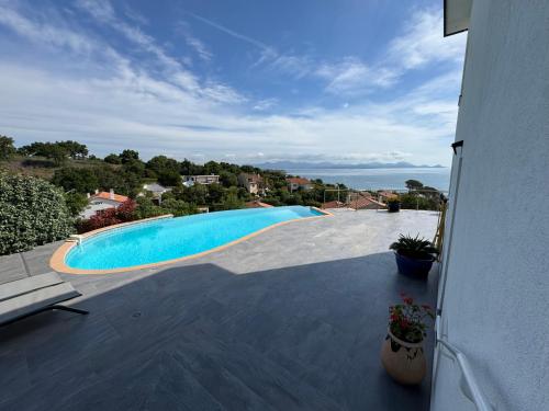 une vue d'une piscine depuis une maison dans l'établissement Rez de villa vue mer et sa piscine privative à débordement, à Saint-Peïre-sur-Mer