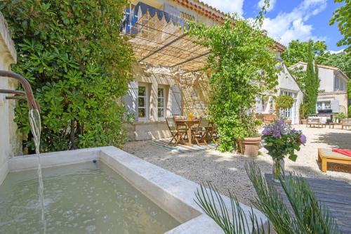 - un jardin avec une piscine d'eau dans la cour dans l'établissement Mas La Thèbaïde, à Paradou