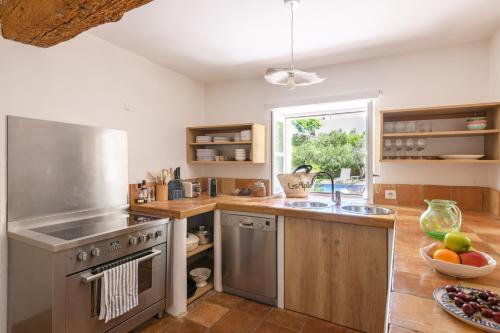 a kitchen with a sink and a stove at Mas La Thèbaïde in Paradou
