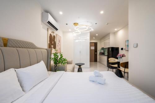 a bedroom with a white bed and a kitchen at Studio-GH5 - Vinhomes Grand Park - Thu Duc City in Long Bình