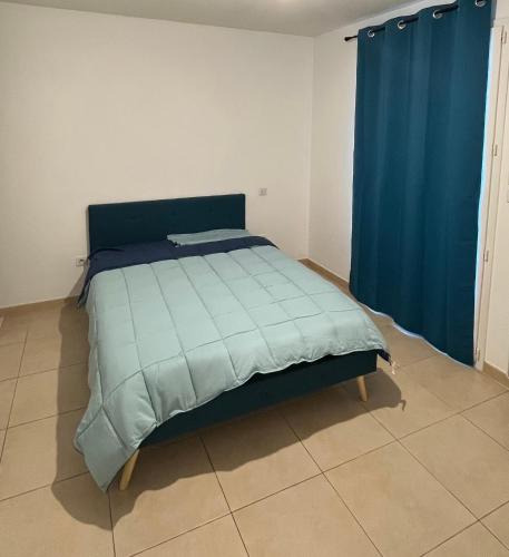 - un lit avec une couette bleue dans l'établissement Charmante VILLA 95 M2, à Vinassan