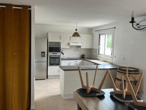 une cuisine avec des armoires blanches et des appareils électroménagers blancs dans l'établissement Charmante VILLA 95 M2, à Vinassan