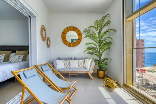 a room with two chairs and a bed and a window at Intempo by Holuxe - 036 - 3rd floor in Benidorm