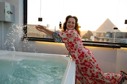 a woman is sitting in a bath tub with water at Sun and Sand Guest House in Giza