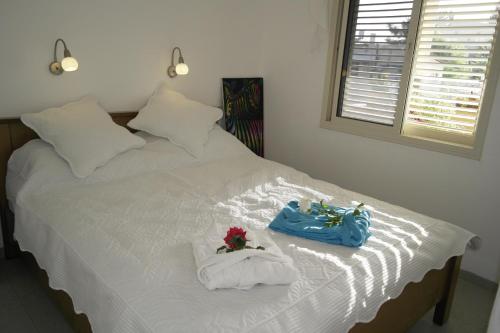 a white bed with two towels and a blue purse on it at צימר ברחובות - Israeli Home in Rechovot