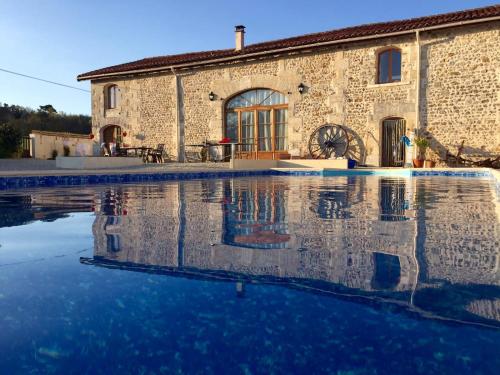 une maison avec piscine devant un immeuble dans l'établissement La Grange farmhouse room with private pool, à Yviers