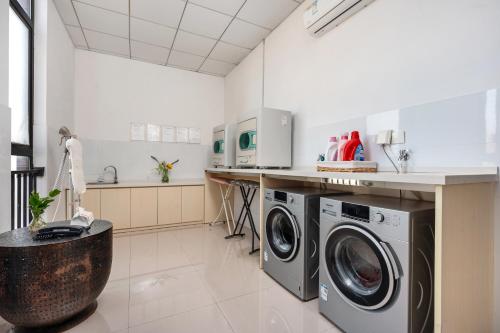 a kitchen with a washing machine and a sink at Manli Hotel Shanghai Pudong Airport Branch -Provide free shuttle buses to Pudong Airport and Disneyland in Shanghai