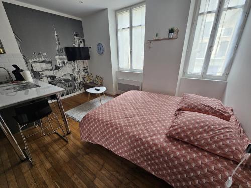 une chambre avec un lit, un bureau et des fenêtres dans l'établissement Le Pastel - grand studio rénové, à Angoulême