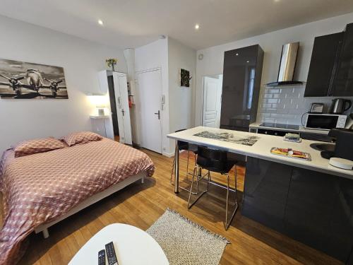 Il comprend une chambre avec un lit et une cuisine avec un bureau. dans l'établissement Le Pastel - grand studio rénové, à Angoulême