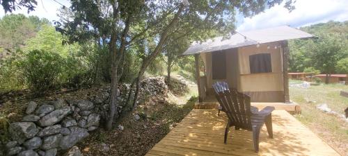 une chaise posée sur une passerelle en bois à côté d'une cabane dans l'établissement La tente de Mercone - Oru, à Corte