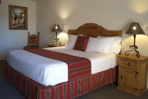 a hotel room with a large bed with two lamps at Beaver Creek Inn in Lake Montezuma
