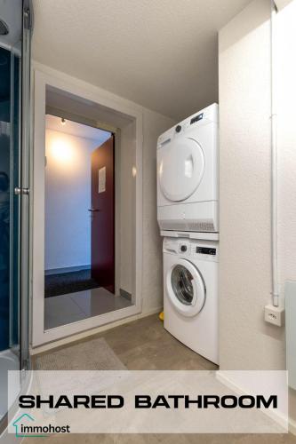 a bathroom with a washing machine and a mirror at Sunny Home near Zurich Airport in Zürich