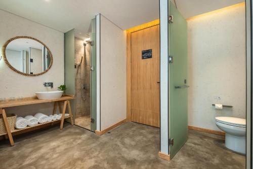 a bathroom with a toilet and a sink and a mirror at Manli Hotel Shanghai Pudong Airport Branch -Provide free shuttle buses to Pudong Airport and Disneyland in Shanghai