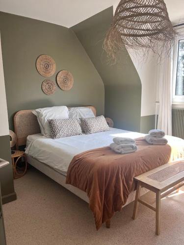 une chambre avec un lit avec des serviettes dessus dans l'établissement Les Glycines, à Croix