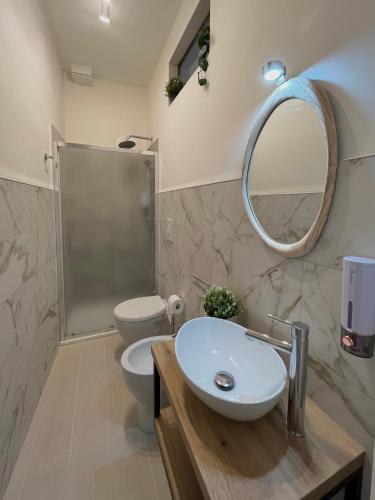 a bathroom with a sink and a toilet and a mirror at Dimora Chiarina in Mola di Bari