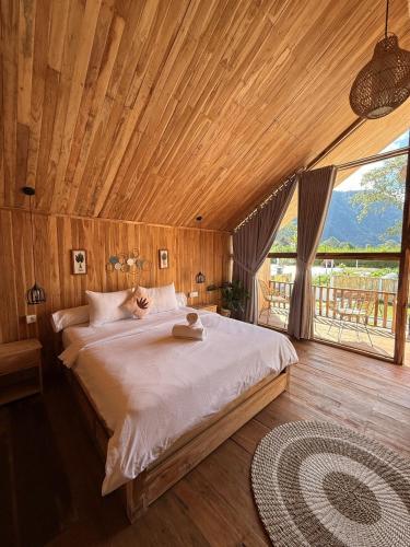 a bedroom with a large bed with a wooden ceiling at Glamour camping bedugul in Bedugul