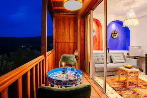 a room with a balcony with a table and chairs at Atlas Smile Retreat in Tassa Ouirgane