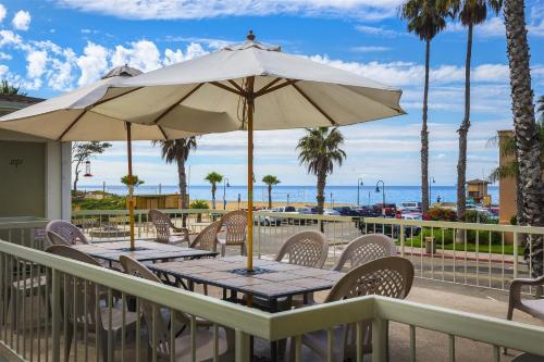 a table with an umbrella on a deck with the beach at 4950 Sandyland Road #127 condo in Carpinteria
