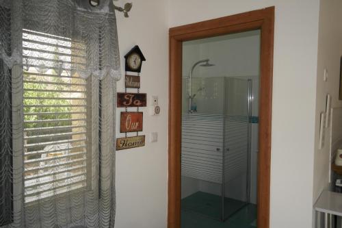 a door to a bathroom with a shower and a clock at צימר ברחובות - Israeli Home in Rechovot