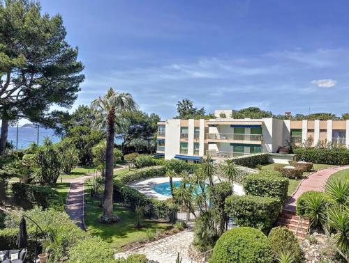 - une vue sur l'extérieur d'un complexe avec une piscine et des arbres dans l'établissement Appartement vue & front de mer, piscines, 55M2 2Pièces, à Cannes