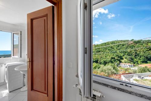 a bathroom with a window and a view of the ocean at Villa Zafferano Suites - Origano in Celle Ligure