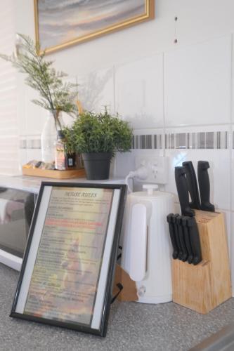 a sign sitting on top of a kitchen counter with knives at Relaxing Two-Bedroom Retreat Near the Airport in Perth