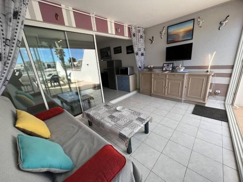 un salon avec un canapé et une télévision dans l'établissement Apt 2 pièces CAP D'AGDE NATURISME CN080-104, au Cap d'Agde